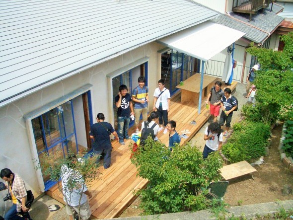 様々な人が集い、交流する庭先のウッドデッキが、このシェアハウスの理念を象徴する。