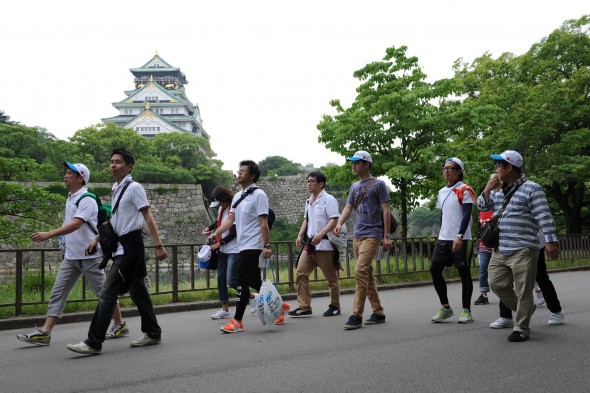 大阪城天守閣を見ながら歩く参加者たち