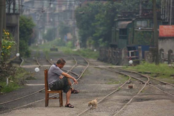 くたびれた軌道に椅子を持ち出して一服する男性。かつてこの山間の小さな街を賑わわせた炭鉱は閉山になり、私が撮影に訪れた翌月には鉄道も廃止になると通告されていた。廃れゆく町を眺め、彼は何を思っていたのだろうか。(2015年、中国四川省にて)